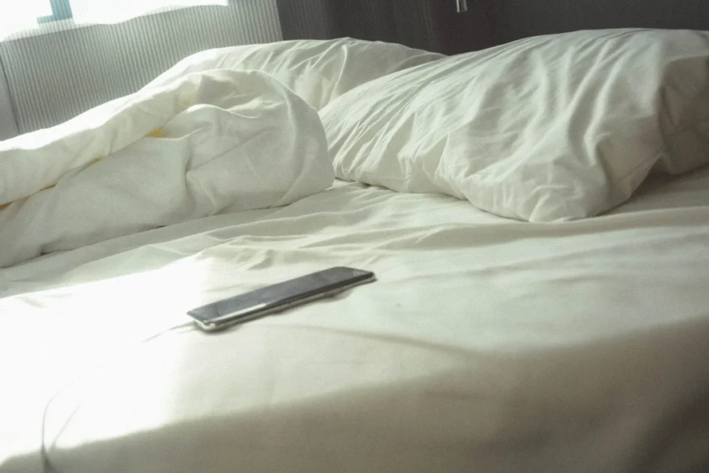 "You're always on your phone" photo of a cell phone lying on a bed