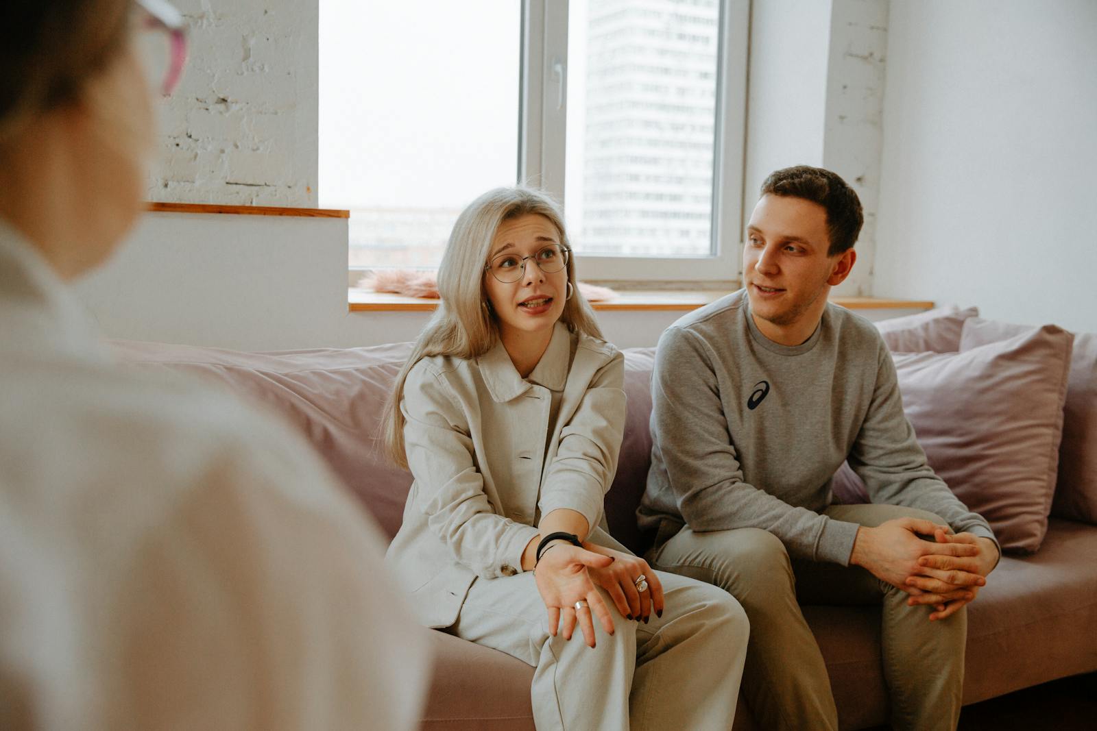 A couple and therapist engaged in a discussion during a divorce counseling session indoors.
