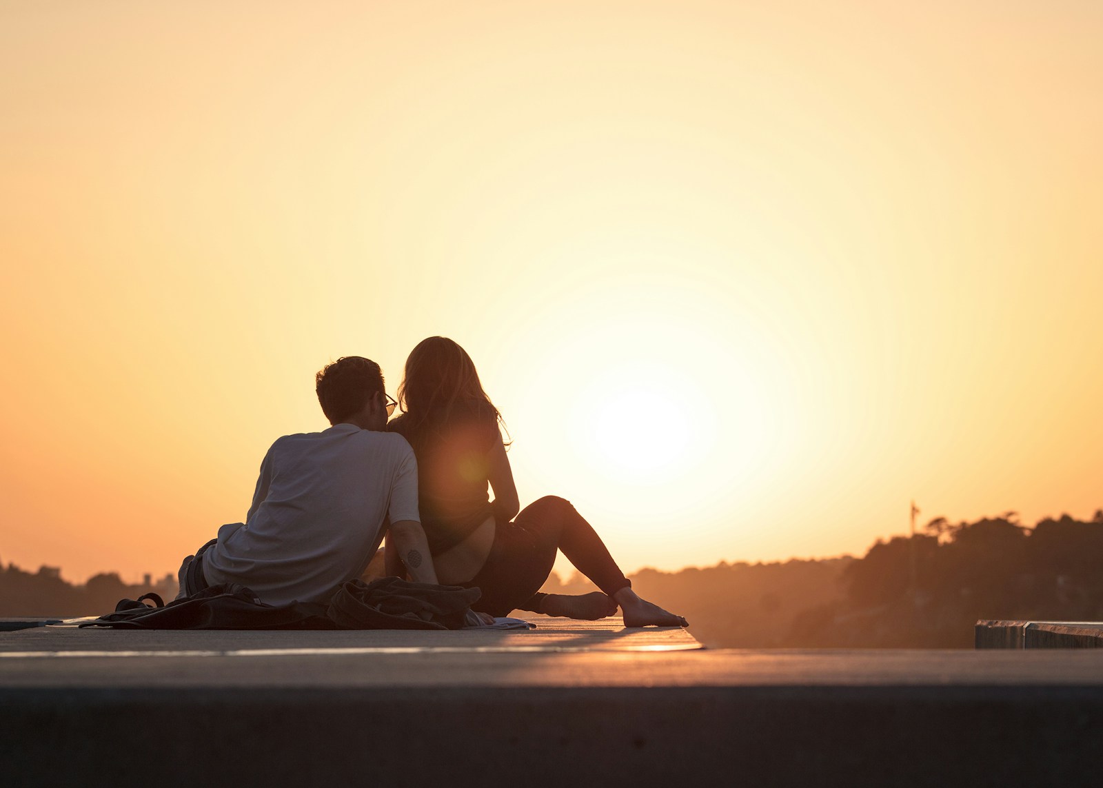 neurodivergent couple sitting near trees during golden hour