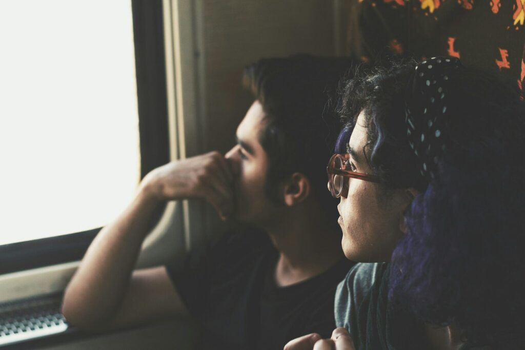 man and woman looking out a window, possibly dealing with postpartum depression
