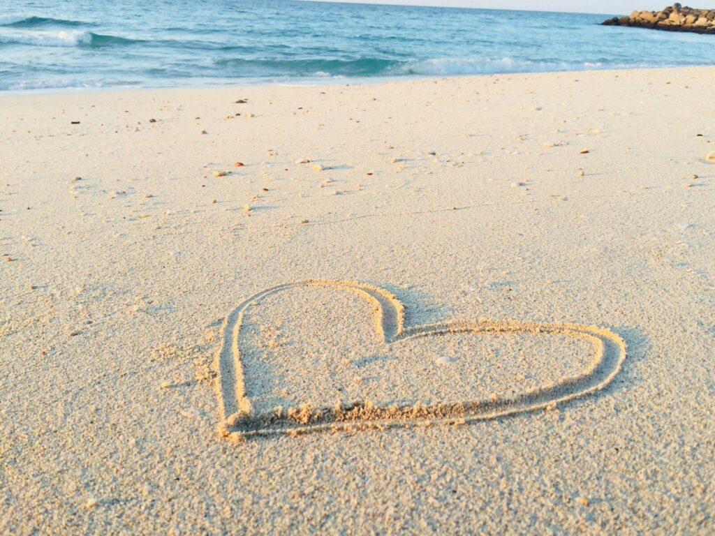 Love - heart drawn on sand during daytime
