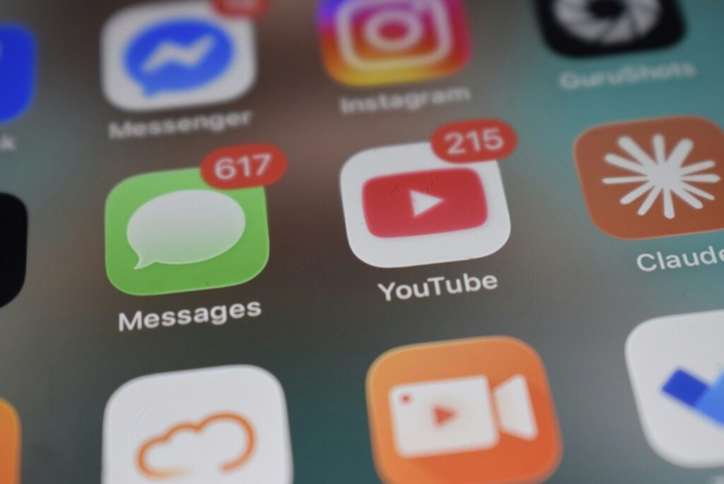 Smartphone screen showing app icons with red notification badges for Messages and YouTube